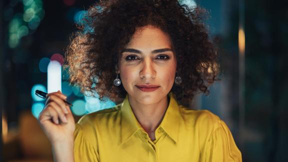 Woman in a yellow shirt with a pen